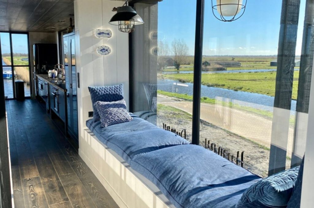 Villapparte-Natuurhuisje-Watervilla-Zwarte-Zwaan-Oostknollendam-luxe-vakantiehuis-op-het-water-6-personen-Zaanstreek-loungebank-in-het-zonnetje
